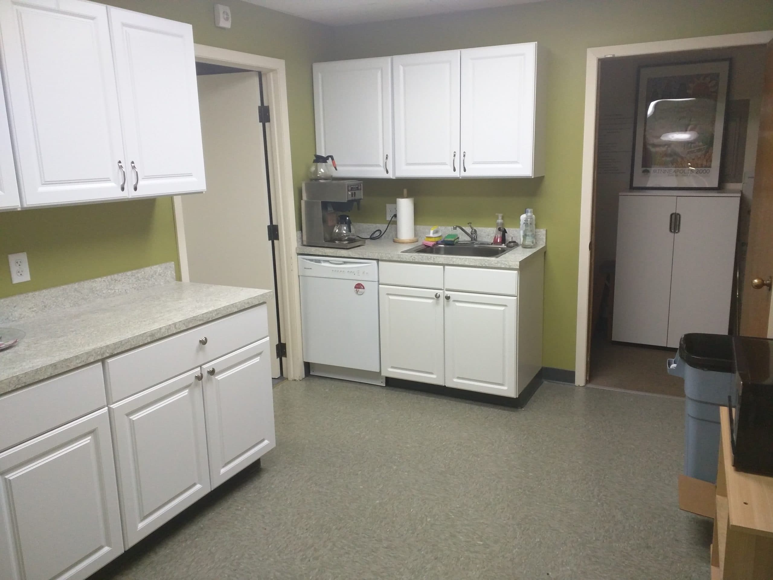 Clubhouse kitchen with coffee maker, sink, and cabinets